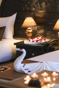 阿加迪尔Hôtel Riad Salam Agadir的一间卧室配有一张床铺,一张桌子上挂着天鹅