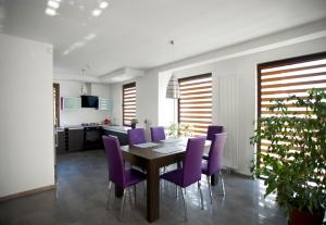 扎莫希奇舒适别墅的一间用餐室,配有紫色椅子和一张桌子