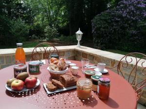 巴尼奥勒德日洛恩Villa Matignon的粉红色的桌子,上面有食物和饮料