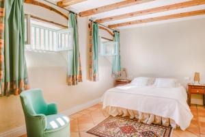 洛斯雷亚莱霍斯Finca el Patio的一间卧室配有一张床和一把绿色椅子