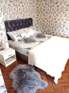 KalviaiInkiliuko apartamentai Ketvergiuose的一间卧室配有一张床和毛绒地毯。