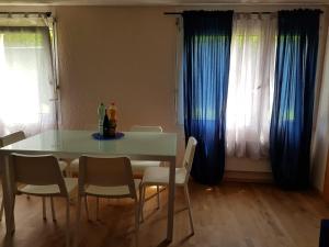 Haag2 Rooms cosy Apartment near Liechtenstein的一张餐桌和椅子,配有蓝色窗帘