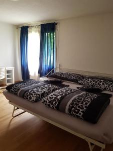Haag2 Rooms cosy Apartment near Liechtenstein的卧室内的两张床,配有蓝色窗帘