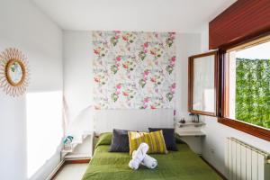 莫格罗Apartamento con vistas al mar-Ola del atardecer的一间卧室,配有一张绿床,上面有一只动物填充物