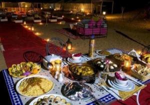 梅尔祖卡Merzouga luxurious Camps的一张桌子上放着许多盘子的食物