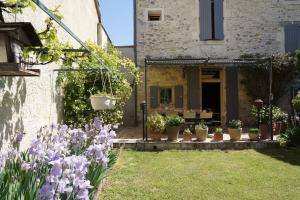 LapaludMaison en Provence的一座花园,在房子前面种有紫色的花朵