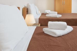 伊里斯斯Dili Apartments的酒店客房,配有两张带白色毛巾的床