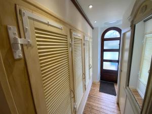 圣马洛Maison bord de mer « Le Bateau IvRe »的铺有木地板的走廊和带百叶窗的门