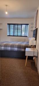 Thamesmead3 bed bedroom house with garden的一间卧室设有一张大床和一个窗户。