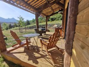BlieuxLa Peyregoune, logement en pleine nature et table d'hôtes的小屋的门廊配有桌椅