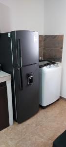 佩雷拉Cómodo apartaestudio con excelente ubicación的厨房配有黑色冰箱、洗衣机和烘干机