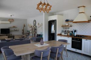 达利安Villa Dionyssos的厨房以及带木桌和椅子的客厅。