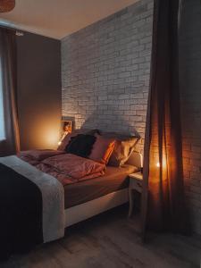 埃尔布隆格Apartament Ohar Downtown的砖墙房间的一个床位