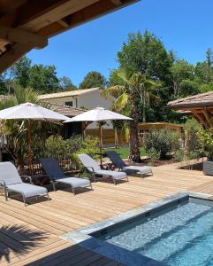 拉卡诺VillaCanau的一个带椅子和遮阳伞的庭院和一个游泳池