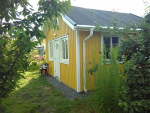 赫尔辛堡Attefallshus byggt 2019的院子中带长凳的小黄色房子