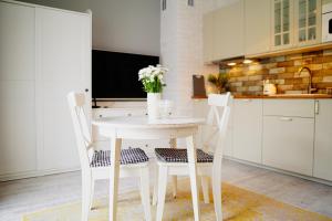 埃尔布隆格Apartament Ohar Downtown的厨房配有白色的桌子和两把椅子