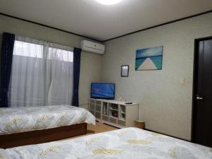 坂井市Bibi Vacation Rental Only 2 groups per day Vacation STAY 5768的一间卧室配有两张床和一台平面电视