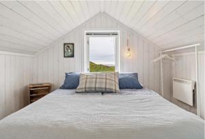 Gimsøy罗弗敦山林小屋的一间卧室设有一张大床和窗户