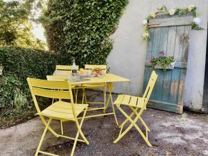 基尔拉什Lemonade Cottages and Retreat的坐在大楼旁边的一张黄色桌子和椅子