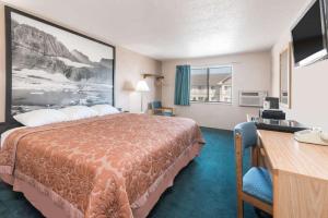 格伦代夫Glendive Lodge的配有一张床和一张书桌的酒店客房