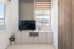 海若克利欧Rooftop Cosy Apartment Perfect Location的一间带电视和窗户的客厅