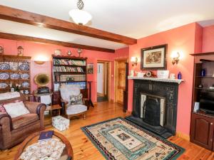 库特希尔An Maide Bán的客厅设有粉红色的墙壁和壁炉