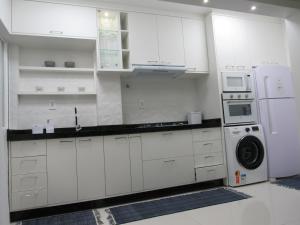 巴拉奈里奥-坎布里乌AP 507 UMA QUADRA DO MAR的厨房配有白色橱柜、洗衣机和烘干机