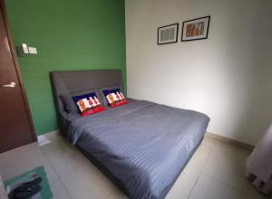 迪沙鲁Desaru Homestay by Home Cube的一张小床,位于带绿色墙壁的房间里