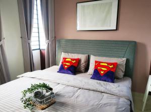 迪沙鲁Desaru Homestay by Home Cube的一张带超人枕头的床和摄像头
