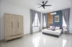 迪沙鲁Desaru Homestay by Home Cube的一间卧室配有一张床和吊扇