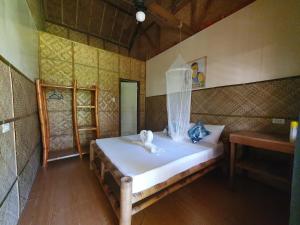 洛博克Loboc Cool River Resort的一间卧室配有一张带两个天鹅的床