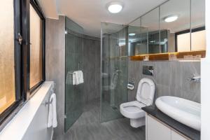 内罗毕CySuites Apartment Hotel的一间带卫生间和玻璃淋浴间的浴室