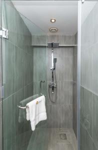 内罗毕CySuites Apartment Hotel的带淋浴和白色毛巾的浴室