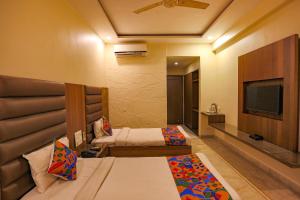 博帕尔FabHotel Surya的酒店客房设有两张床和一台平面电视。