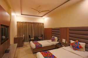 博帕尔FabHotel Surya的酒店客房设有两张床和一张桌子。