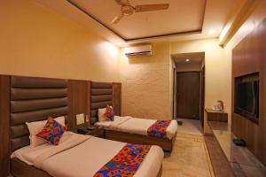 博帕尔FabHotel Surya的酒店客房设有两张床和电视。