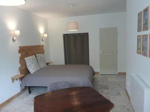 阿列日河畔的塔拉斯孔La Maison d Antoine的一间卧室配有一张床和一张木桌