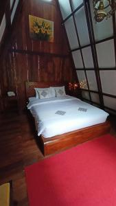 巴图Bliss family cottage Batu的一间卧室配有一张红色地毯的大床