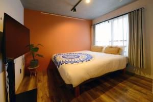 东京Luana Shibuya的一间卧室设有一张大床和一个窗户。