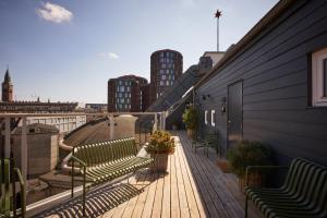 哥本哈根WIDE Hotel的阳台设有长椅,享有城市美景。