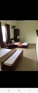 海防Motel TÂY HỒ的酒店客房设有两张床和一张桌子。