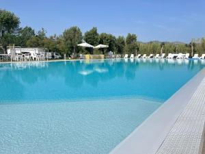 布多尼Resort Abbaia Ba的一个带椅子和蓝色水的大型游泳池
