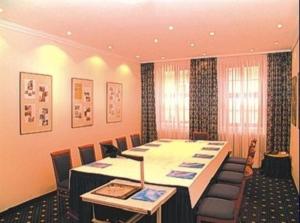 格尔利茨图马赫尔罗曼蒂克酒店的一间会议室,配有长桌子和椅子