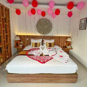 勒吉安The Sakaye Villas & Spa的一间卧室配有一张红色和粉红色气球床。