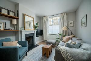 伦敦ALTIDO Contemporary 2-bed house with Private Garden的客厅设有两张沙发和一个壁炉