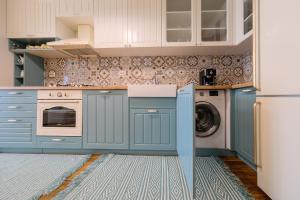 克卢日-纳波卡Grand Park Blue Iulius Mall的厨房配有蓝色橱柜、洗衣机和烘干机