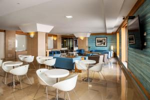 锡尼什斯纳拉马公寓酒店的一间在房间内配有白色椅子和桌子的餐厅