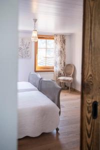 苏姆维特格Casa Pasch - Boutique Bed and Breakfast in Cumpadials的卧室配有床、椅子和窗户。