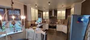 沃加尔Ocean Front Villa的厨房配有白色橱柜和蓝色冰箱。