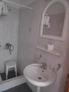 波尔塔里亚Catherine Portaria Guest House的一间带水槽、镜子和凳子的浴室